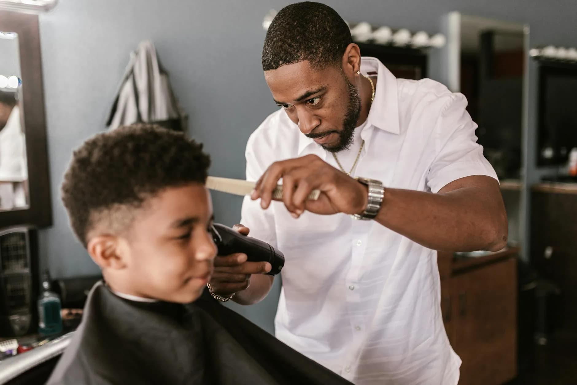 Barber apprentice learning clipper control from an instructor